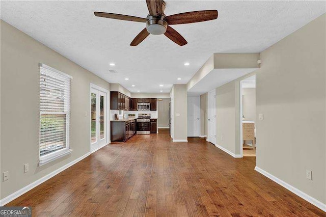 living area with dark wood-type flooring, ceiling fan, baseboards, a textured ceiling, and recessed lighting