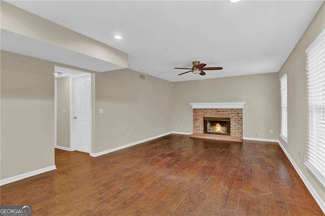 unfurnished living room with ceiling fan, wood finished floors, baseboards, a fireplace, and recessed lighting