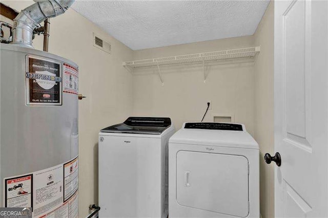 laundry room with gas water heater, independent washer and dryer, and a textured ceiling
