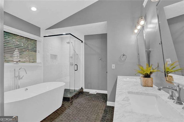 bathroom with a freestanding bath, lofted ceiling, a shower stall, baseboards, and recessed lighting