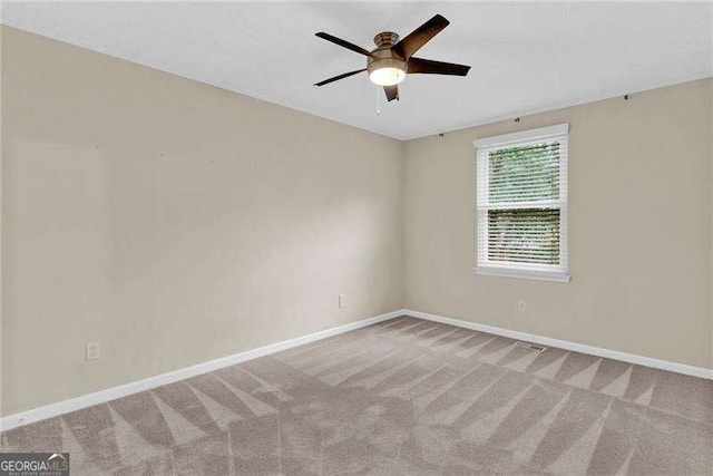 spare room featuring ceiling fan, carpet flooring, and baseboards