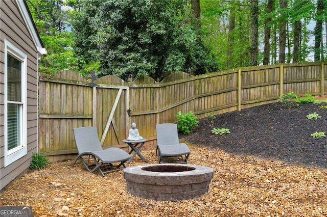 fenced backyard with a fire pit