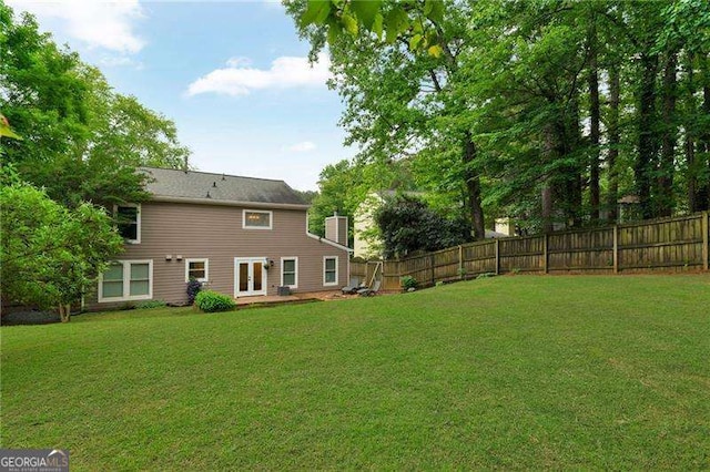 back of property with french doors and a chimney