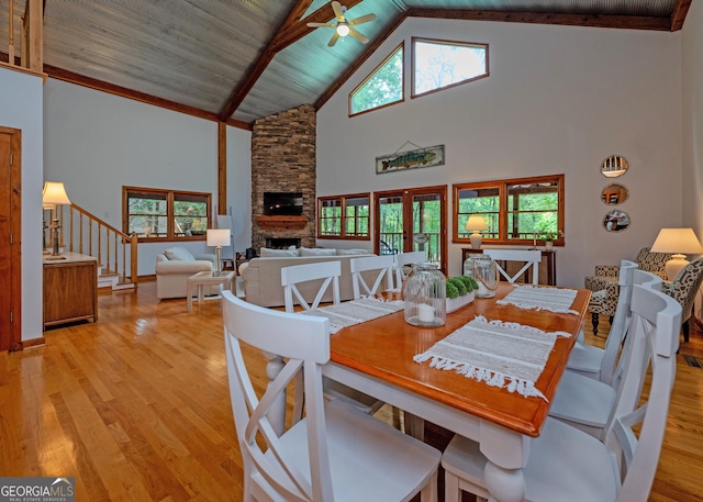 142 Hugh Dorsey Rd, Hartwell, GA 30643 - dining space with high vaulted ceiling, a fireplace, light wood-type flooring, a ceiling fan, and plenty of natural light