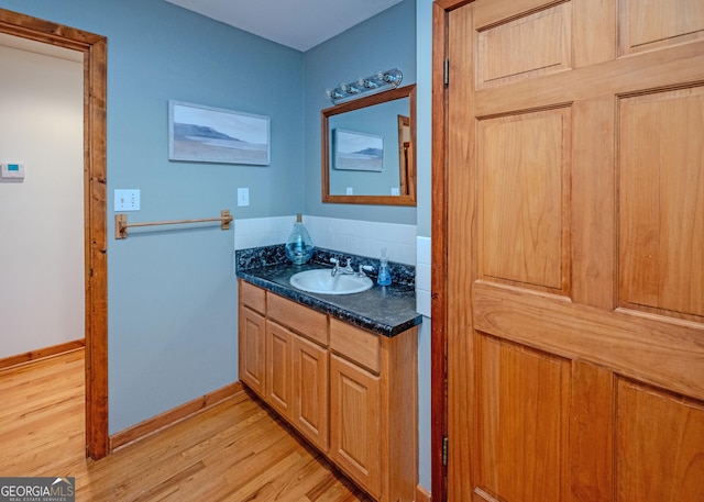 142 Hugh Dorsey Rd, Hartwell, GA 30643 - bathroom featuring wood finished floors, vanity, tasteful backsplash, and baseboards
