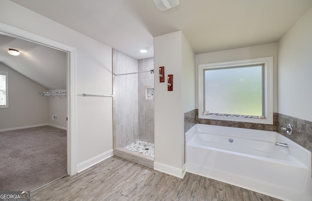 full bath with a garden tub, a tile shower, baseboards, and wood finished floors