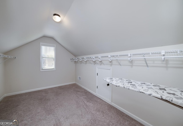 walk in closet with vaulted ceiling and carpet floors