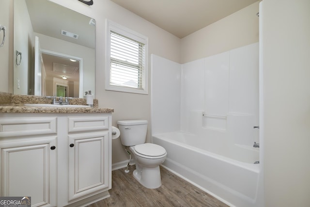 bathroom with toilet, wood finished floors, vanity, baseboards, and shower / tub combination