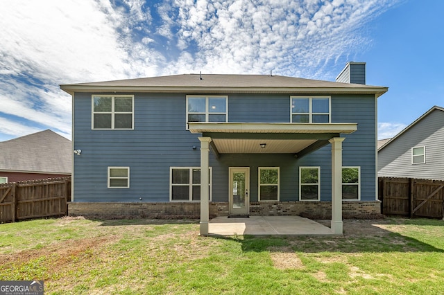 back of property with a patio area, brick siding, and a chimney