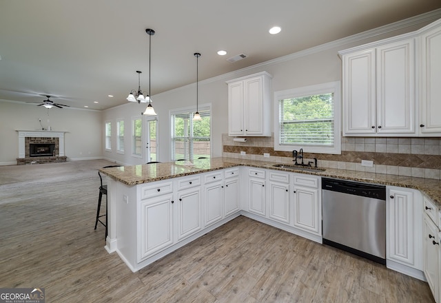 kitchen with stainless steel dishwasher, a sink, a ceiling fan, tasteful backsplash, and a peninsula