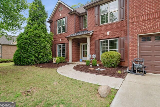 4960 Tadmore Ln, Lithonia, GA 30038 - view of front facade featuring brick siding, a front lawn, a garage, and concrete driveway