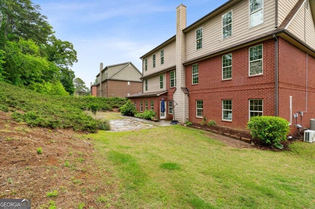 4960 Tadmore Ln, Lithonia, GA 30038 - back of property featuring a yard, brick siding, and a chimney