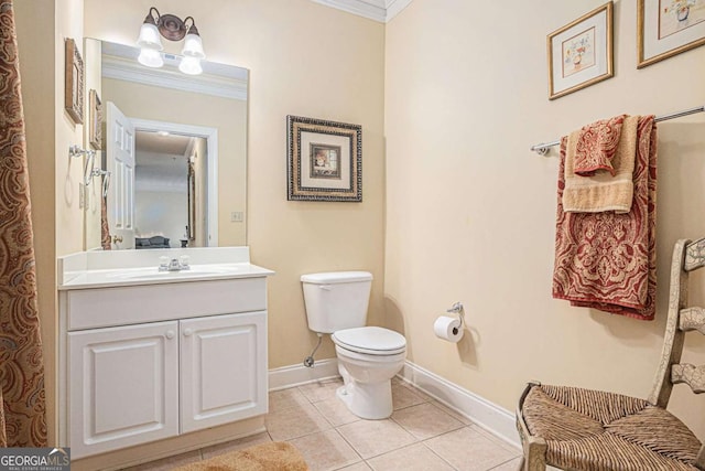 bathroom with toilet, baseboards, tile patterned floors, crown molding, and vanity