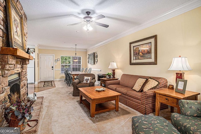 carpeted living area featuring ceiling fan, crown molding, a textured ceiling, and a fireplace