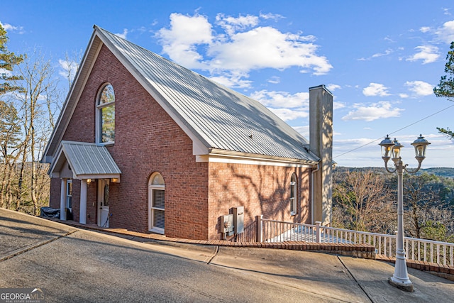 626 Palisade Dr, Ellijay, GA 30540 - view of front facade with brick siding, a metal roof, and a chimney