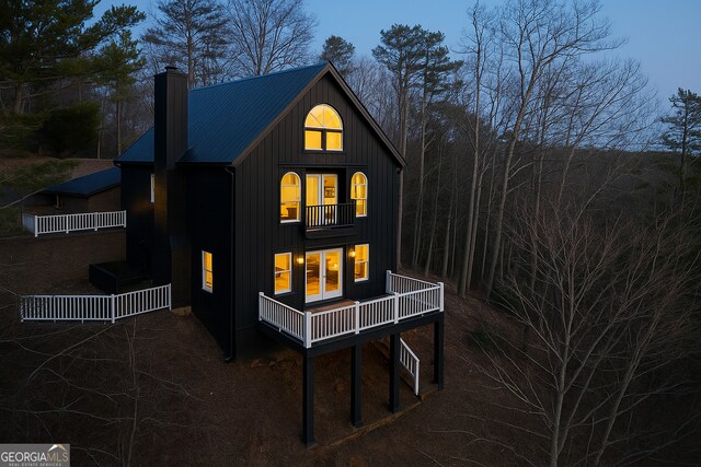 626 Palisade Dr, Ellijay, GA 30540 - rear view of house featuring a chimney, board and batten siding, a balcony, and a metal roof