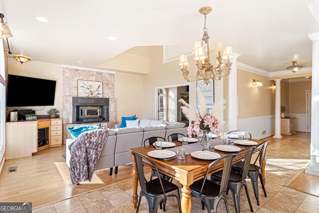 626 Palisade Dr, Ellijay, GA 30540 - dining space featuring decorative columns, a chandelier, a tile fireplace, ornamental molding, and a wainscoted wall