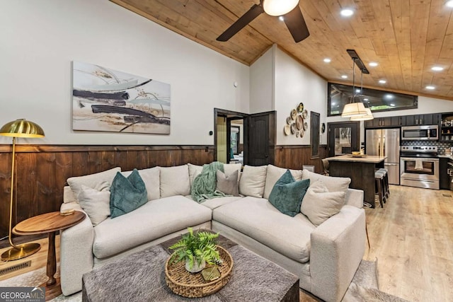 living room with wood ceiling, vaulted ceiling, wainscoting, light wood-style floors, and recessed lighting