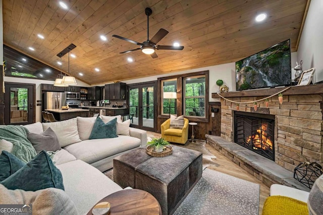 living room featuring wood ceiling, lofted ceiling, recessed lighting, wood finished floors, and a stone fireplace