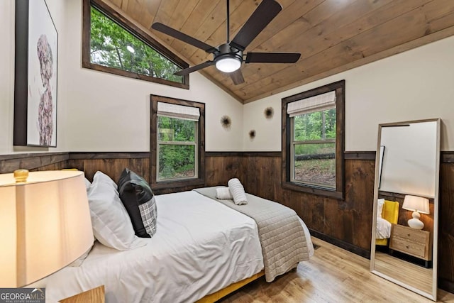 bedroom featuring wainscoting, wooden ceiling, wood finished floors, lofted ceiling, and wood walls
