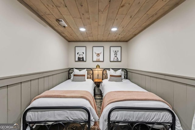 bedroom with recessed lighting, wood ceiling, and wainscoting