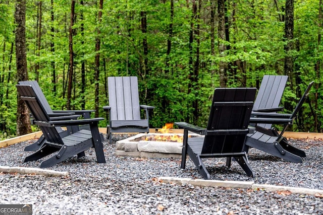 view of patio / terrace with a fire pit and a wooded view