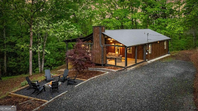 view of outbuilding featuring an outdoor fire pit and a view of trees