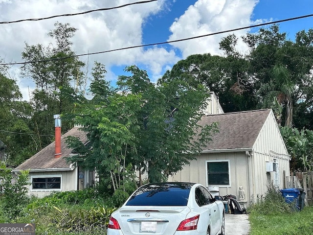 view of front facade featuring roof with shingles and board and batten siding