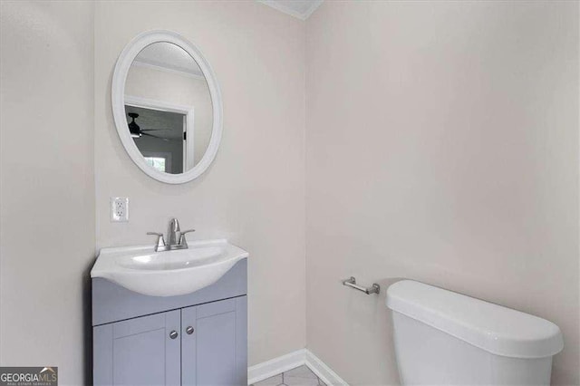 half bath with a ceiling fan, vanity, toilet, and crown molding