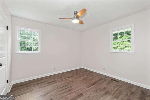 unfurnished room with wood finished floors, baseboards, and ceiling fan