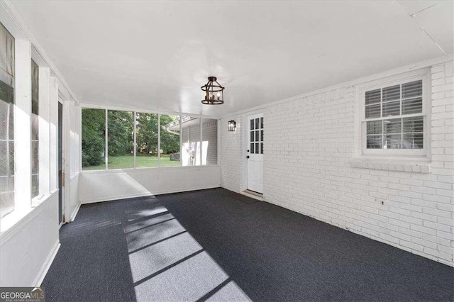 unfurnished sunroom featuring a chandelier