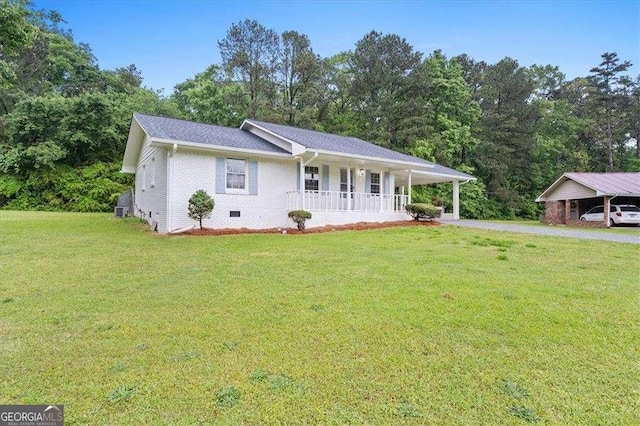 ranch-style house featuring a porch, a front yard, a carport, brick siding, and driveway
