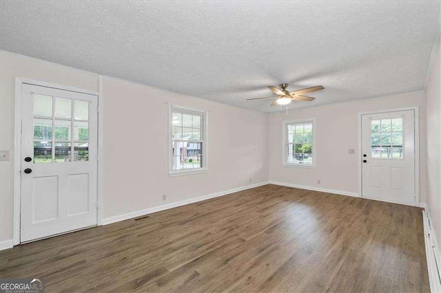 foyer entrance featuring a textured ceiling, wood finished floors, ceiling fan, and baseboards