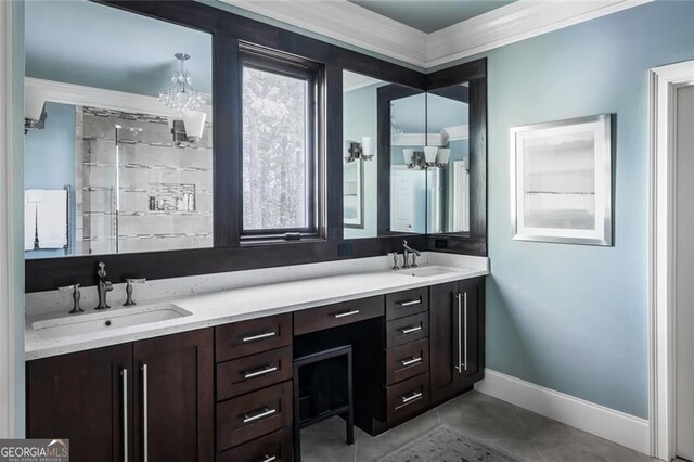 full bath with a chandelier, ornamental molding, double vanity, baseboards, and tile patterned flooring