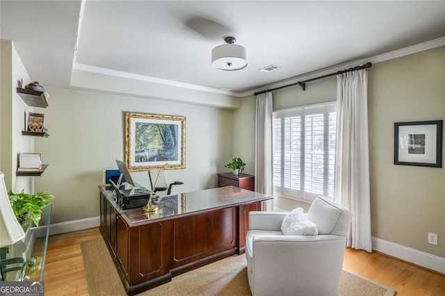 office space featuring light wood-style floors, baseboards, and crown molding