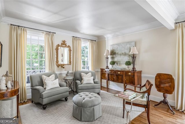 sitting room with ornamental molding and wood finished floors