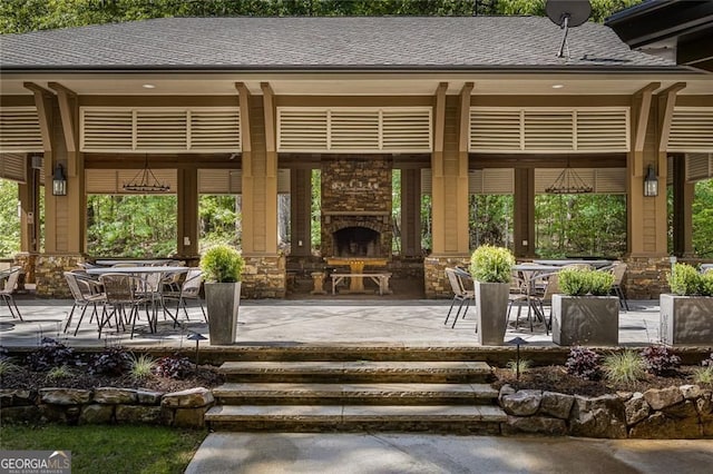 view of patio featuring an outdoor stone fireplace and outdoor dining area