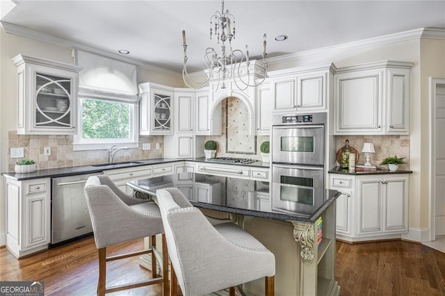 kitchen featuring stainless steel appliances, a chandelier, dark wood-style flooring, tasteful backsplash, and crown molding