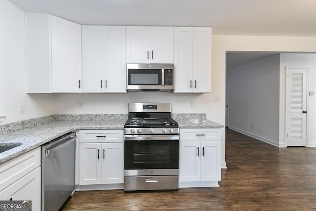 3215 Pennignton Cir, Atlanta, GA 30354 - kitchen featuring appliances with stainless steel finishes, dark wood-type flooring, white cabinetry, light stone countertops, and baseboards