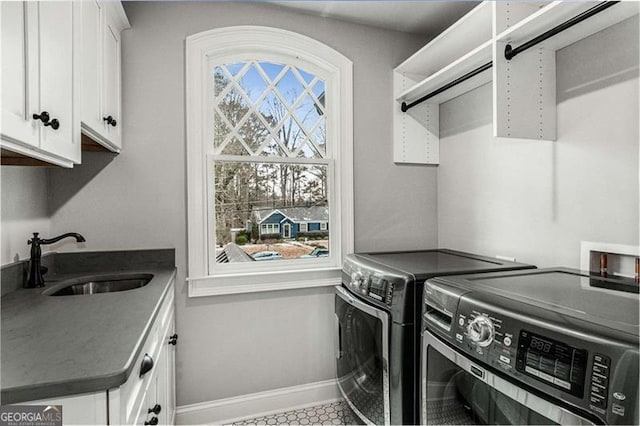 laundry room featuring cabinet space, washer and dryer, and baseboards