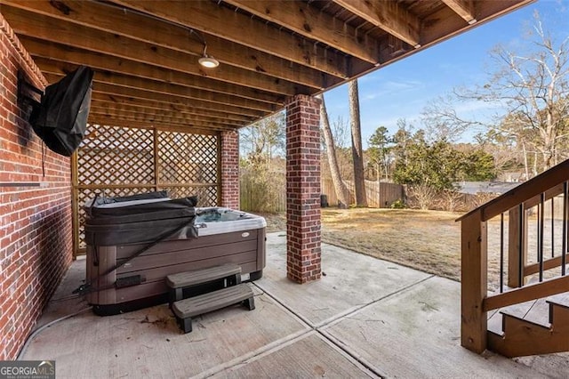 view of patio / terrace with a hot tub and a fenced backyard