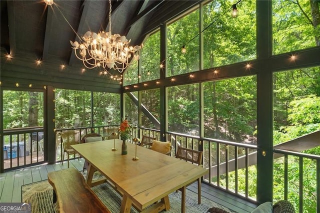 sunroom / solarium featuring a chandelier, outdoor dining area, and healthy amount of natural light
