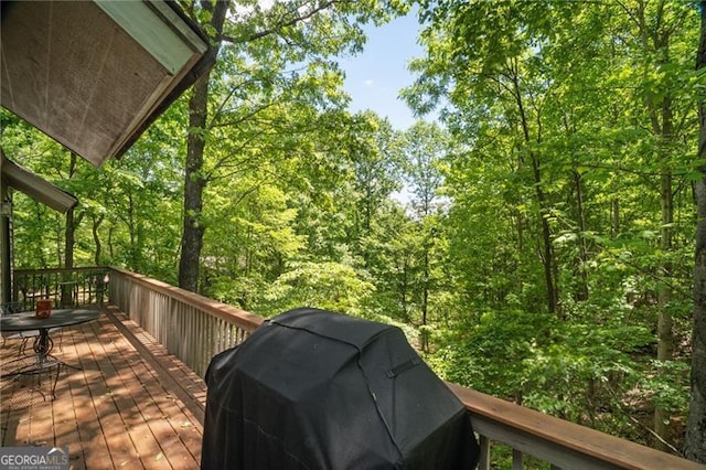 deck featuring a grill and a wooded view
