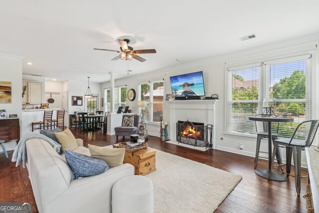 840 Yosemite Dr, Suwanee, GA 30024 - living area featuring ceiling fan, a fireplace, healthy amount of natural light, crown molding, and dark wood-type flooring
