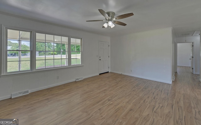 unfurnished living room with attic access, a ceiling fan, light wood finished floors, and baseboards