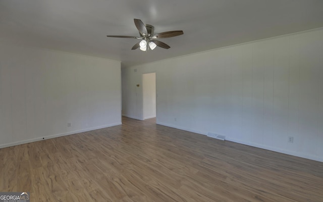 empty room featuring ceiling fan, wood finished floors, and baseboards