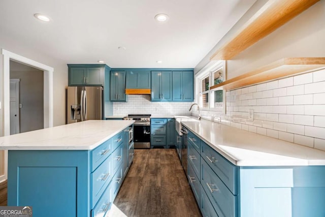 kitchen featuring appliances with stainless steel finishes, dark wood finished floors, backsplash, a kitchen island, and recessed lighting