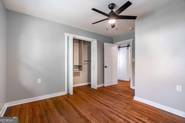 unfurnished bedroom with baseboards, wood finished floors, a closet, and ceiling fan
