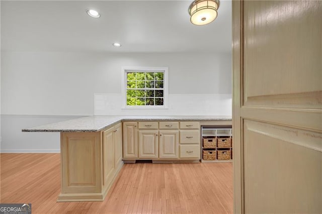 kitchen with light wood-style flooring, light brown cabinetry, a peninsula, recessed lighting, and light stone counters