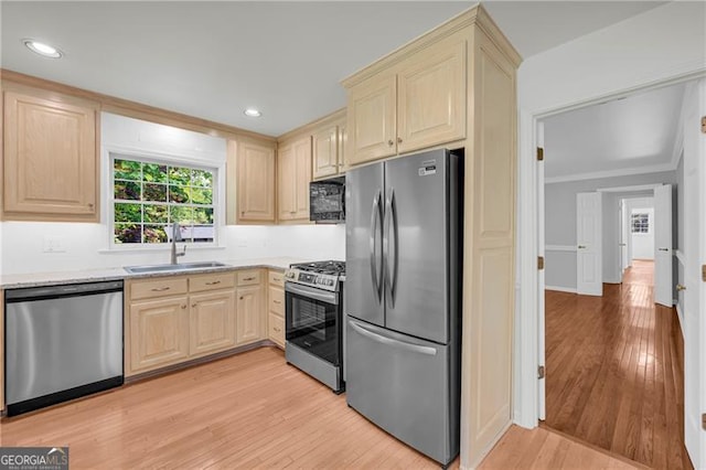 kitchen with stainless steel appliances, a sink, light brown cabinetry, light wood-style flooring, and recessed lighting